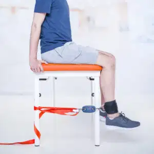 Why Assessing Muscle Strength in COPD Patients Is a Game-Changer in Respiratory Rehabilitation 3 A patient sitting on a treatment chair measuring lower limb muscle strength using the Kinvent K-Pull sensor attached to an ankle strap