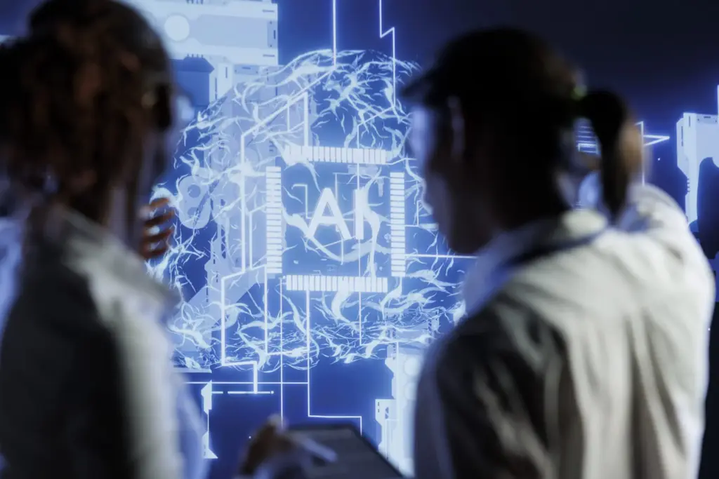 Deux scientifiques vus de dos analysant un grand écran numérique bleu brillant représentant un réseau de neurones artificiels et l'inscription AI, illustrant les défis de la gestion des données et de l'intelligence artificielle en kinésithérapie