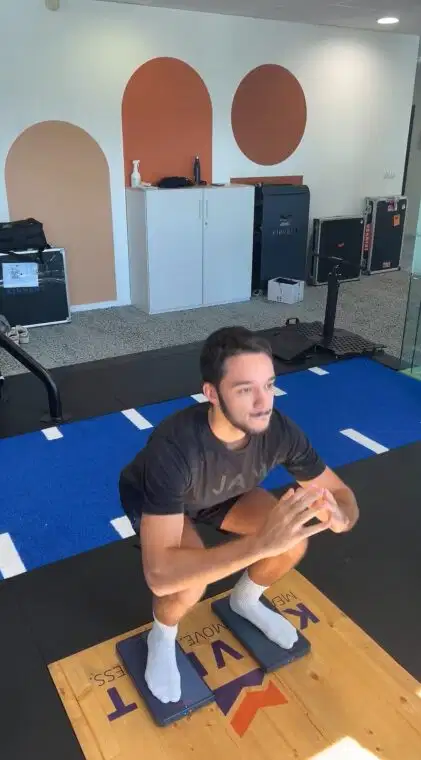 Los cuatro pilares del movimiento humano: movilidad, estabilidad, fuerza y movimiento funcional explicados 7 A man performing a deep squat on two Kinvent connected force plates to measure balance and leg strength symmetry