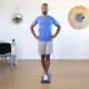 Balanceo postural tras el reemplazo de rodilla: la importancia de la complejidad del equilibrio para prevenir caídas 4 Man standing with hands on hips performing a balance test on Kinvent force plates to evaluate postural sway