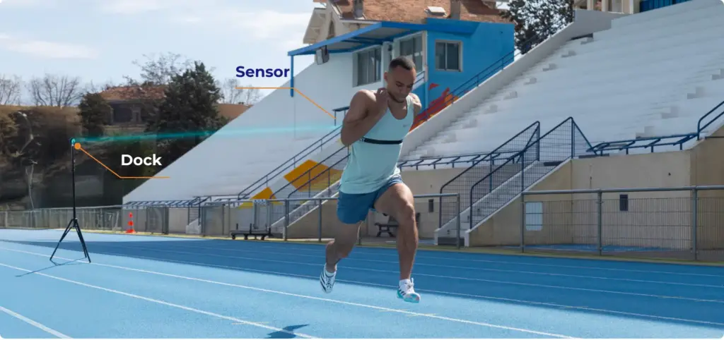 Perfil fuerza-velocidad en el sprint: cómo K-Power transforma el entrenamiento de la velocidad 25 Athlete sprinting on a blue track using the K-Power force profiling system, highlighting the tripod base and the back-worn sensor