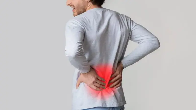 Low Back Pain: Clinical Assessment, Validated Tests, and Evidence-Based Management 2 Man holding his lower back with a red glowing area representing low back pain or lumbar inflammation