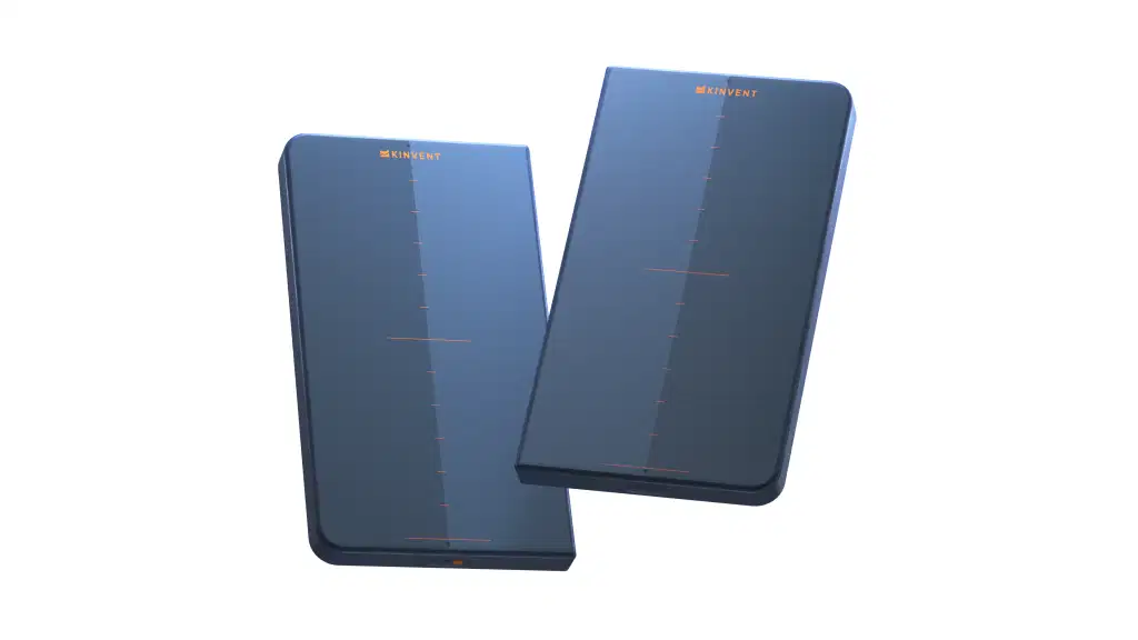 A 3D product render of two dark blue rectangular Kinvent K-Force Plates isolated on a transparent background, featuring an orange "KINVENT" logo and a thin orange crosshair measurement grid on their smooth surface