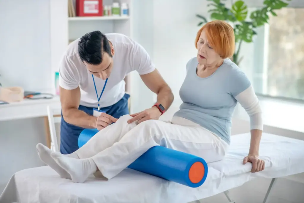 Professional physical therapist examining a patient's knee in a modern clinic, illustrating physical therapy practice management