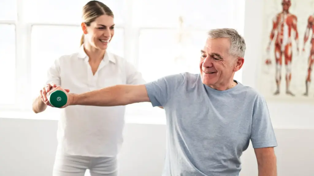 Older patient performing upper-limb strengthening exercises with a physical therapist during cardiac rehabilitation.