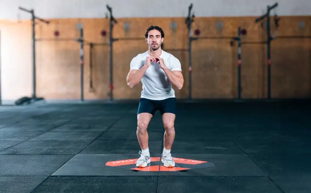 3D Deltas 46 An athlete performing a squat jump on a Kinvent 3D Deltas force plate in a gym setting