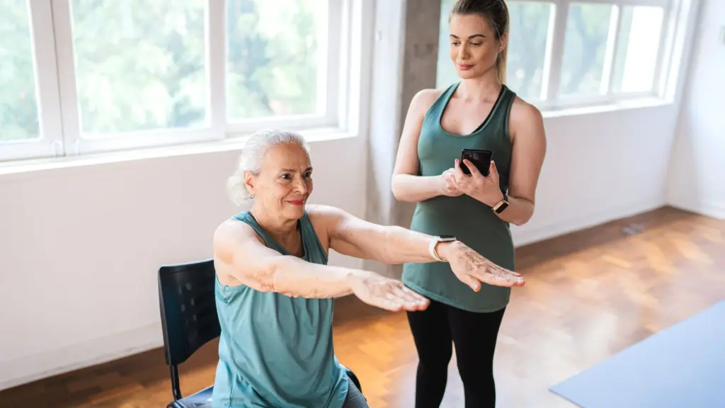 a woman doing physical activity with a coach at home to prevent breast cancer