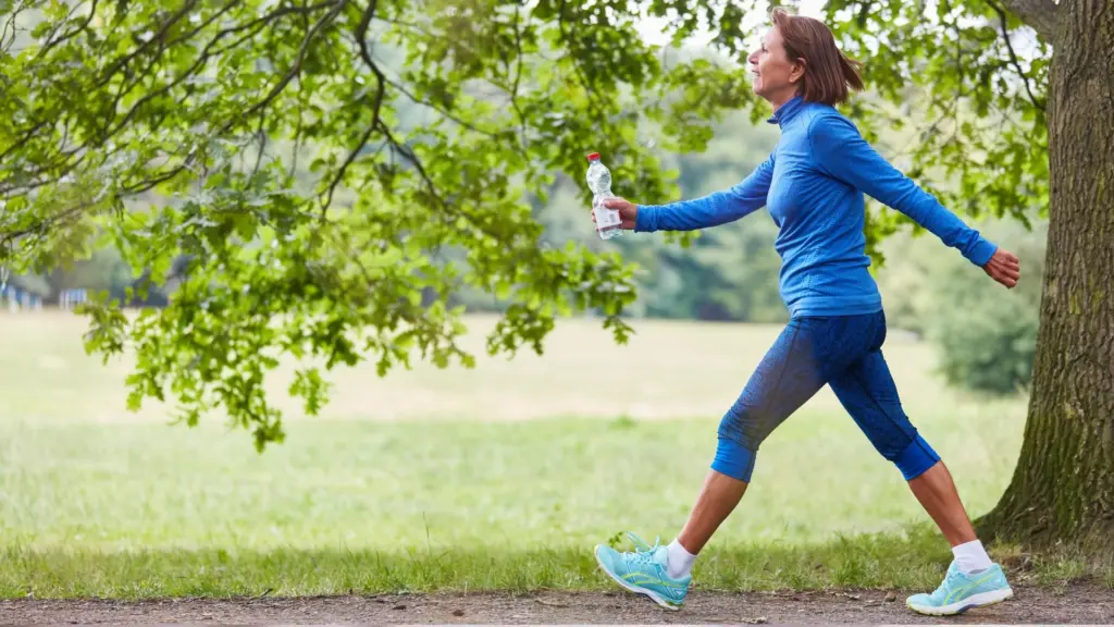 A woman walking in nature to reduce cancer-related fatigue preserve muscle mass and strength; maintain or improve cardiorespiratory fitness